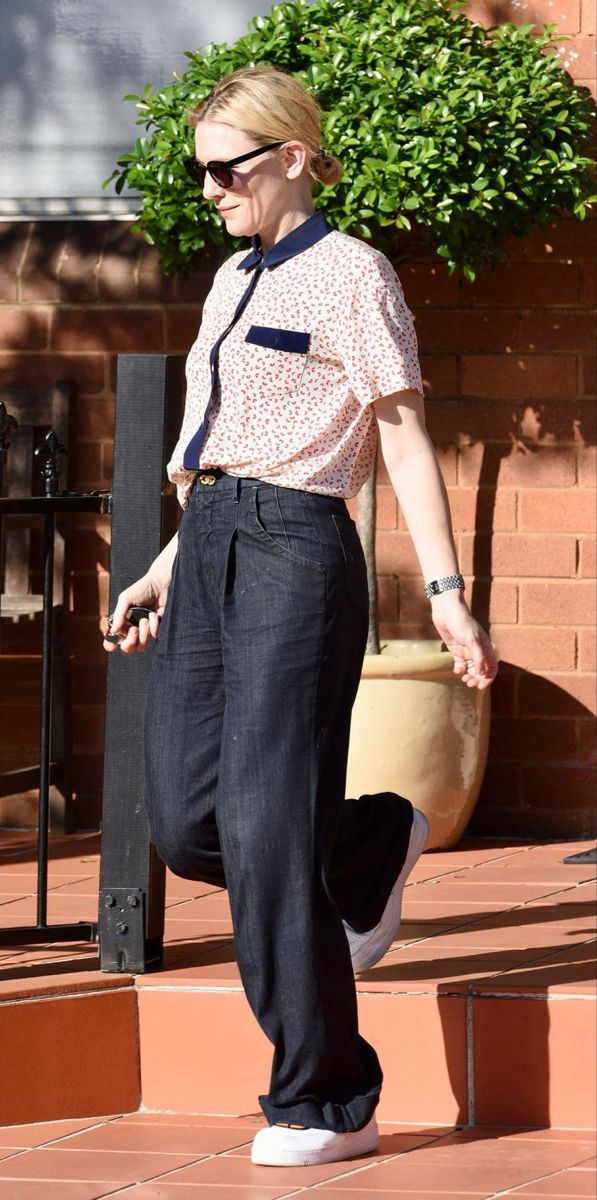 a woman walking down the street with her hand in her pocket