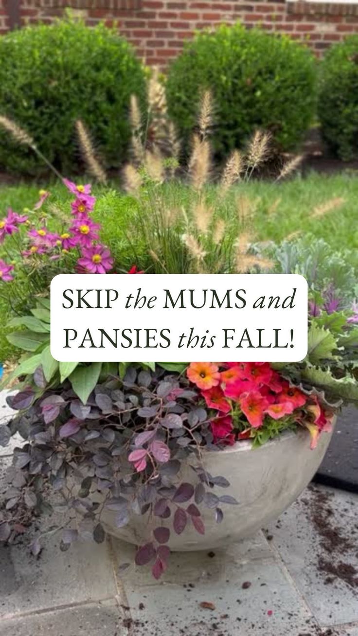 a planter filled with lots of flowers sitting on top of a sidewalk