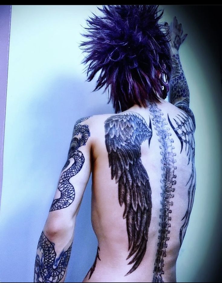 the back of a man with tattoos on his body