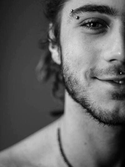 black and white photograph of a man with piercings on his forehead