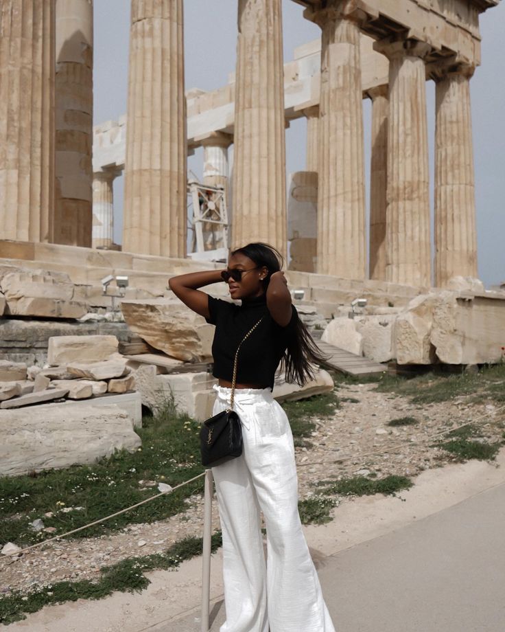 a woman standing in front of the parthenion with her hand on her head