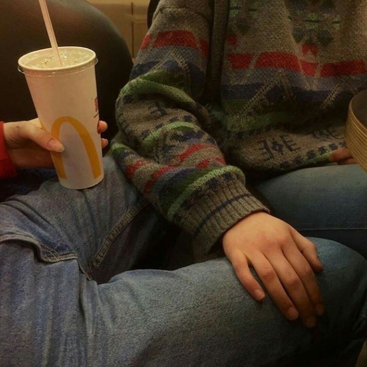 a person sitting down with a drink in their hand