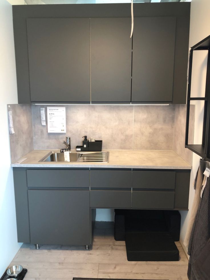 a kitchen with gray cabinets and white counter tops