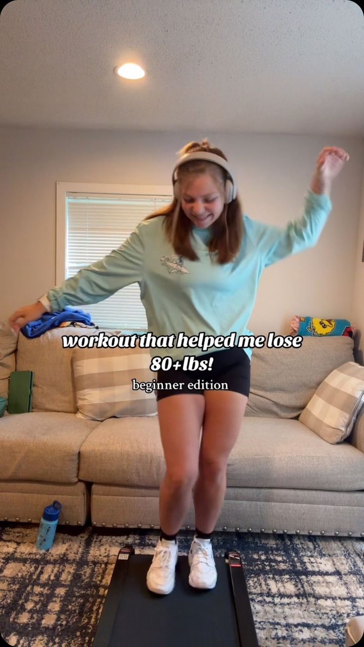 a woman standing on top of a scale in front of a couch