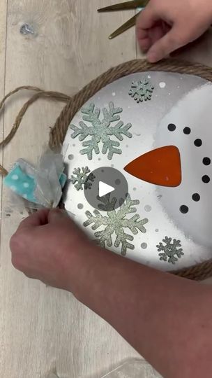 someone is making a snowman ornament out of rope