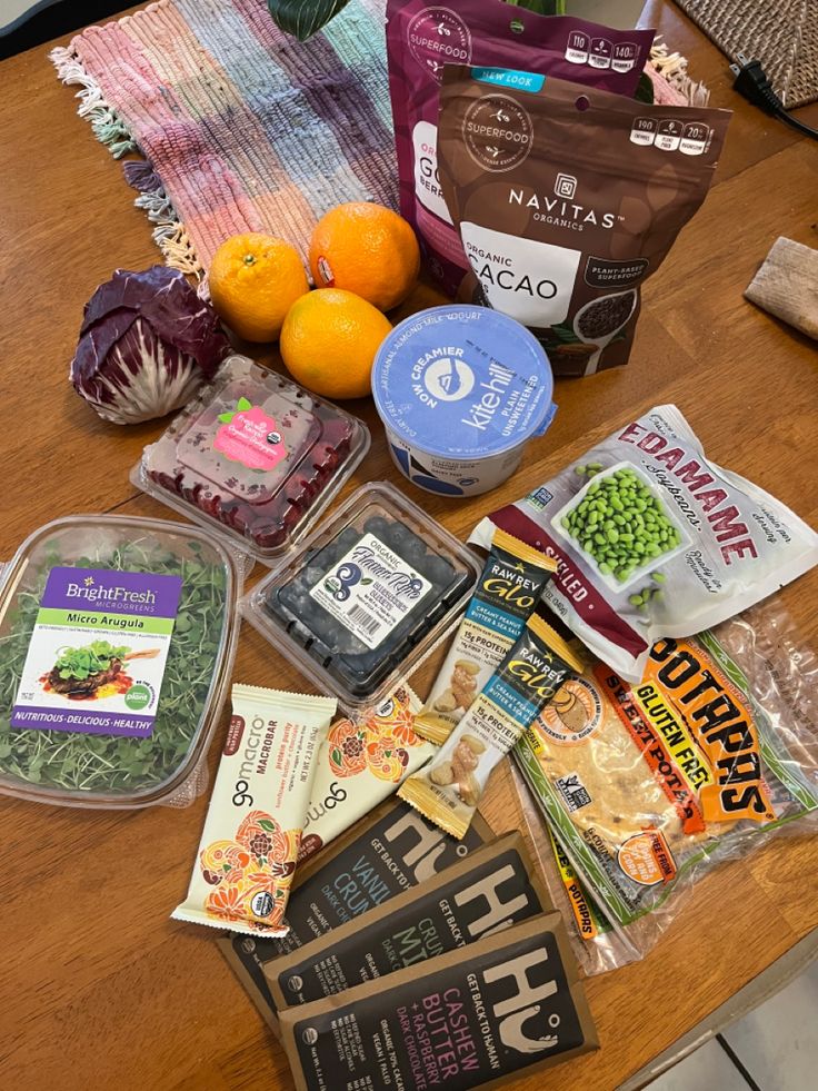 an assortment of food on a table with some oranges and other items around it