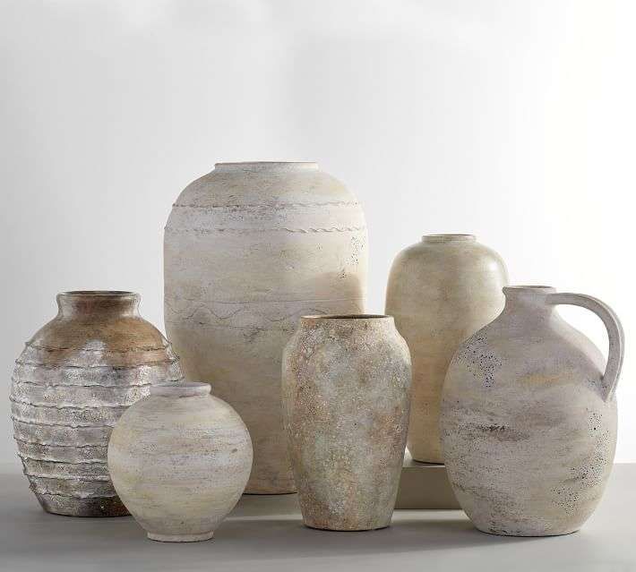 several white vases are stacked on top of each other in different shapes and sizes