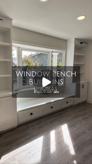 an empty living room with windows and built in bookshelves