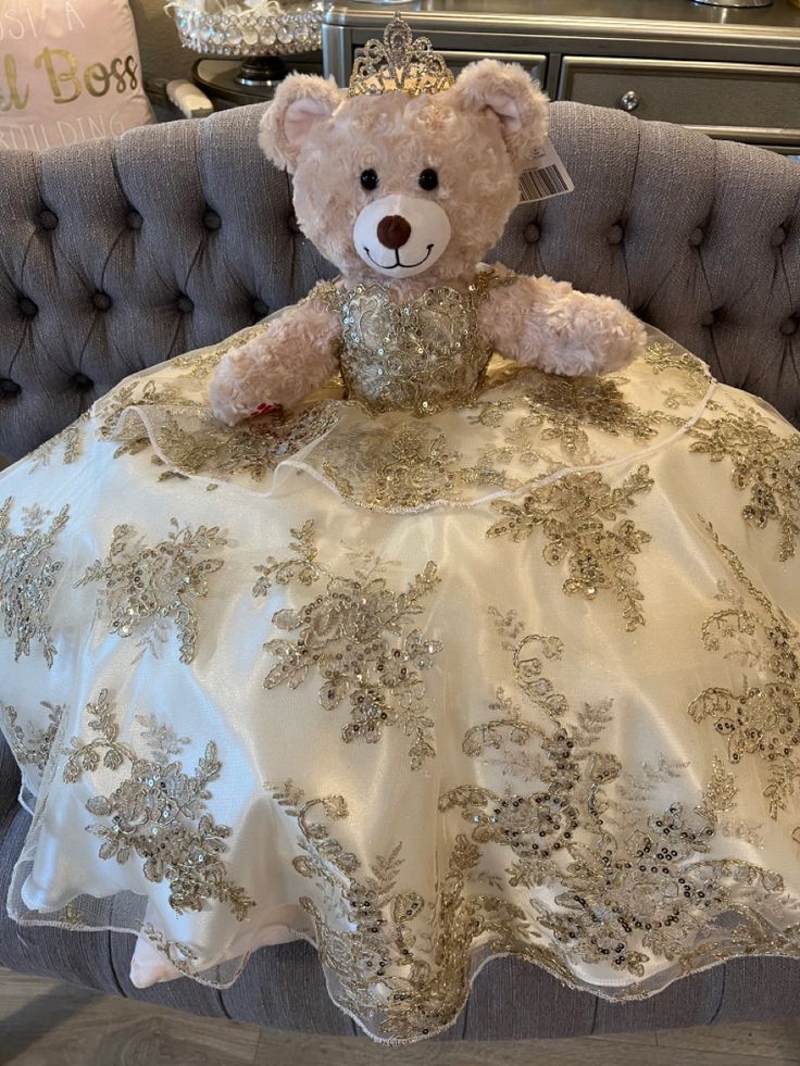 a teddy bear sitting on top of a couch in a dress with sequins