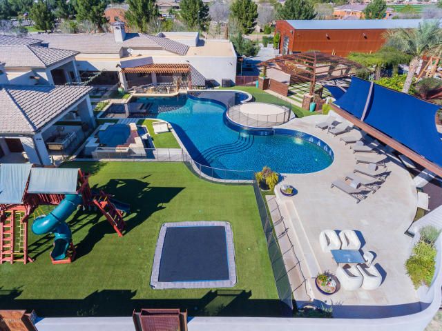 an aerial view of a backyard with a swimming pool and children's play area