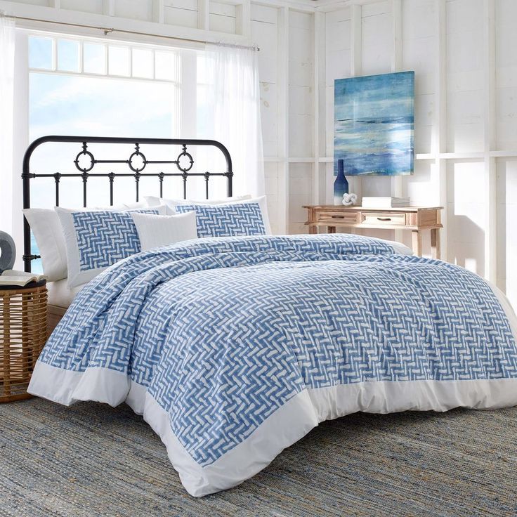 a bed with blue and white comforters in a room