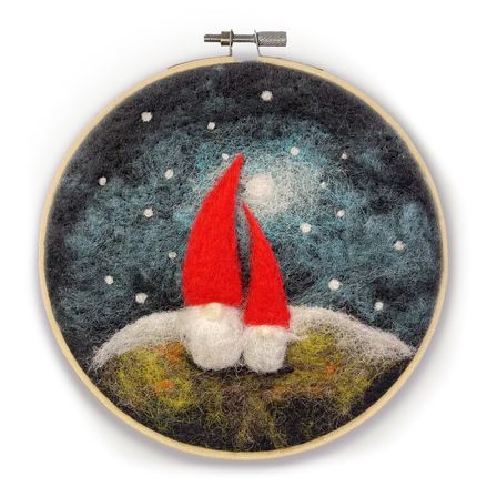 a needle - embroidered ornament with a santa hat on top of a hill