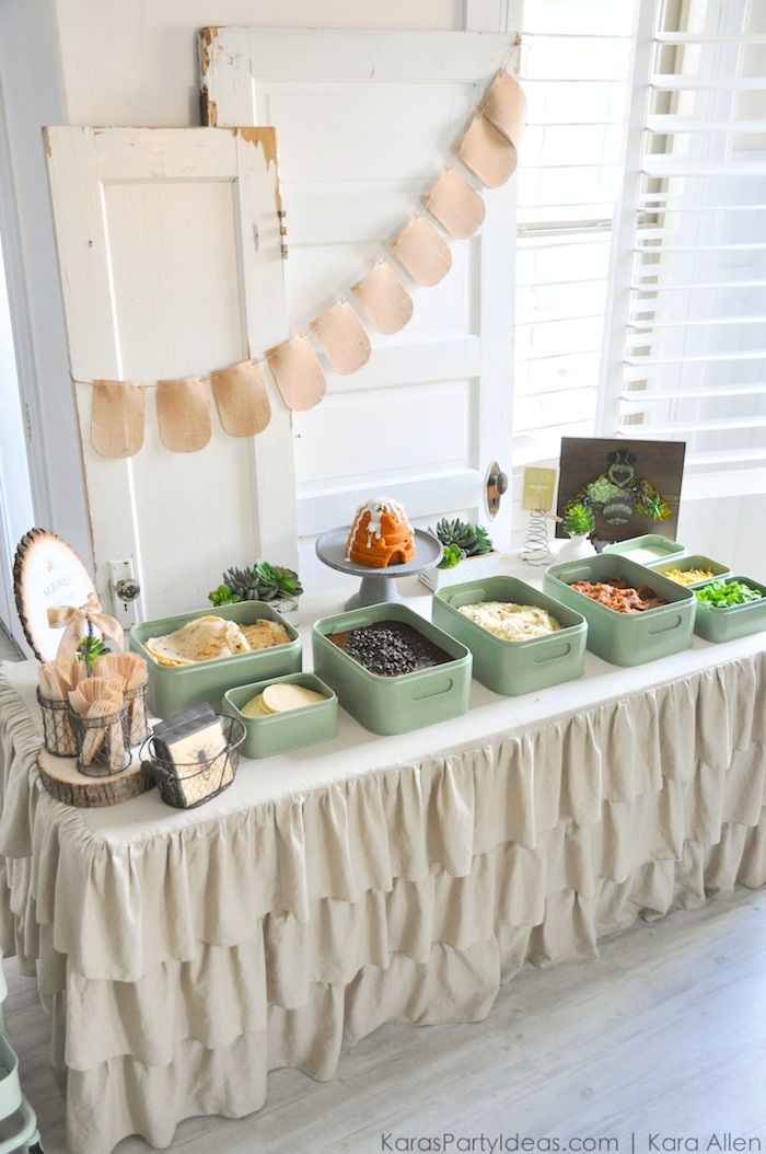 a table topped with lots of food on top of a white table covered in burlap