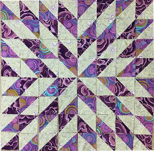 a purple and white quilt with an abstract design