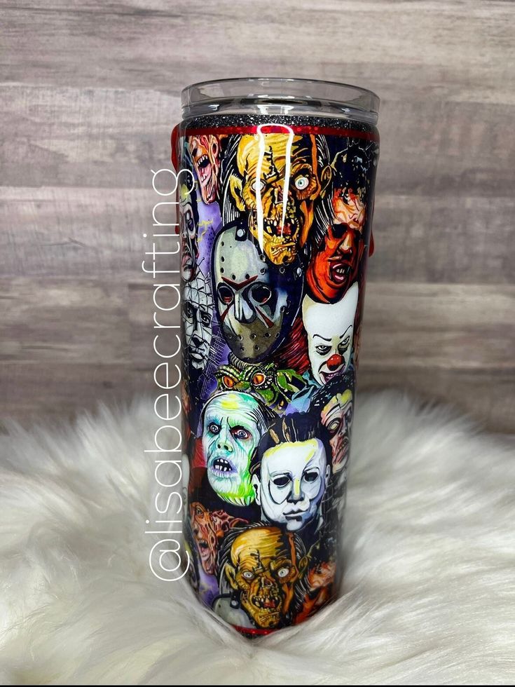 the tumbler cup has many different faces on it and is decorated with white fur