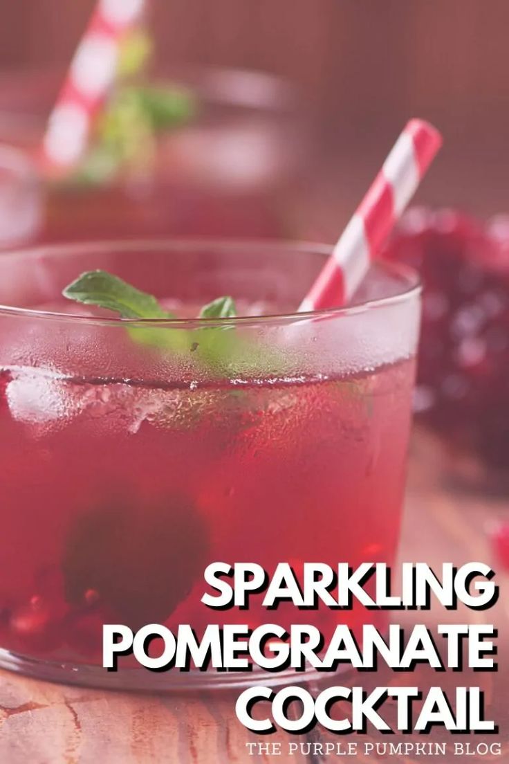 sparkling pomegranate cocktail in a glass with strawberries and mint garnish