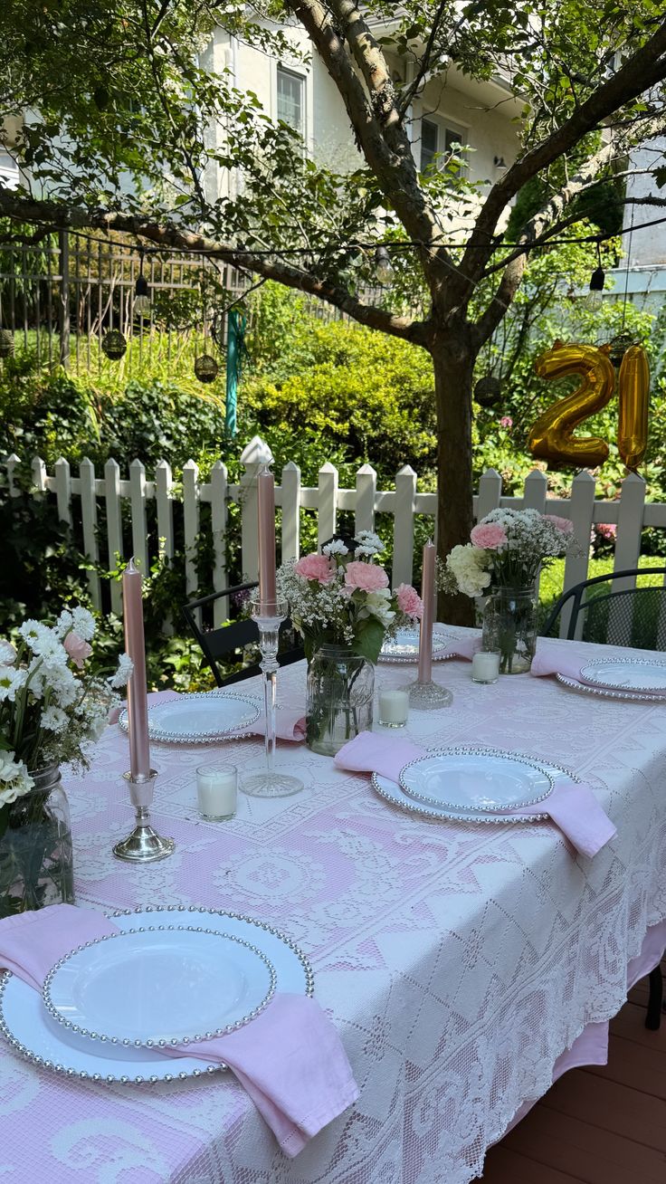 the table is set with pink and white place settings for two people to sit at