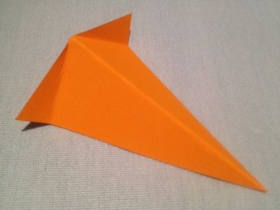 an orange origami bird sitting on top of a table