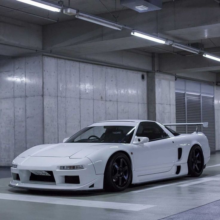 a white sports car parked in a parking garage