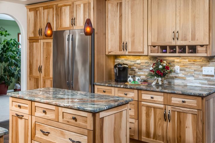 a large kitchen with wooden cabinets and granite counter tops, along with stainless steel appliances