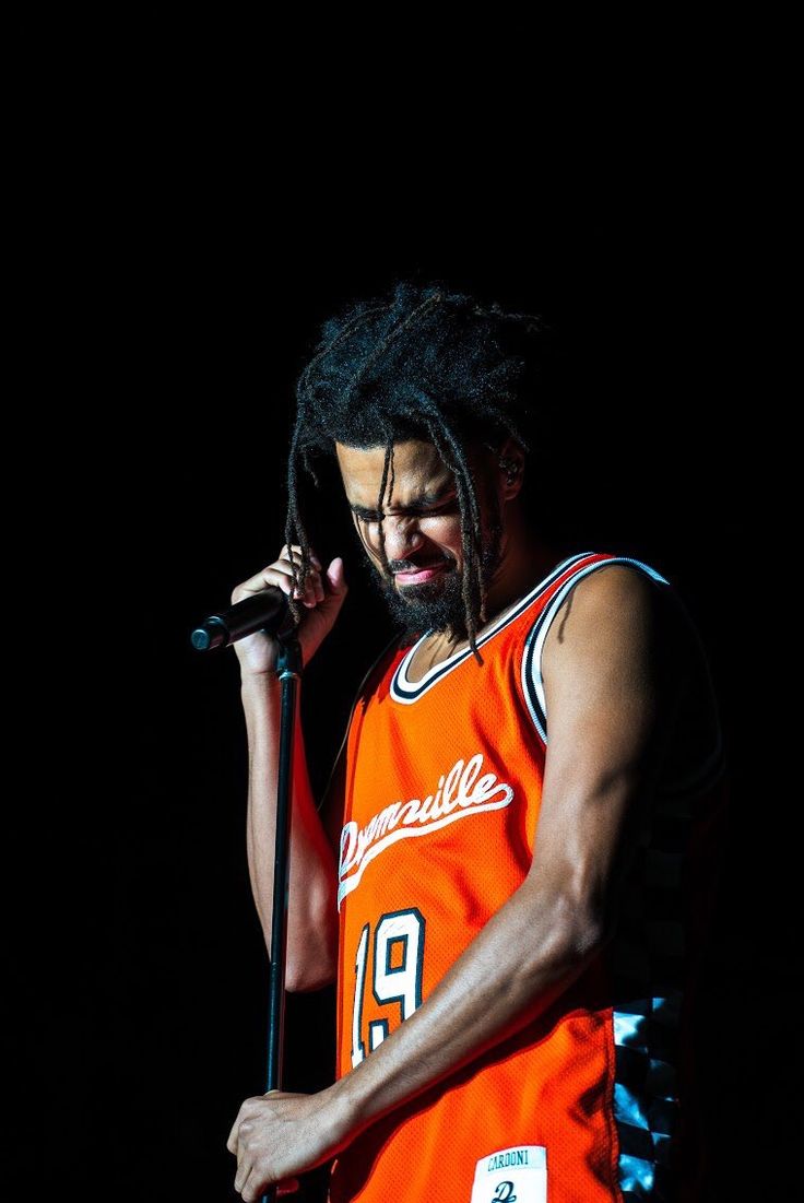 a man with dreadlocks holding a microphone