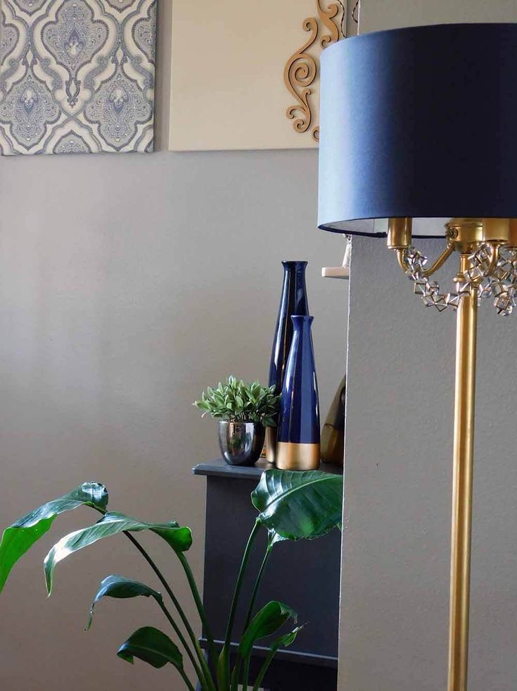 a blue lamp sitting on top of a table next to a potted plant