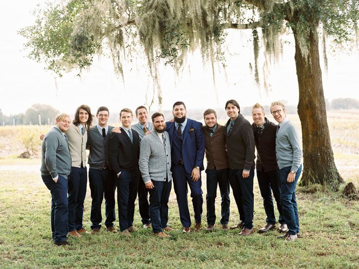 a group of young men standing next to each other in front of a large tree