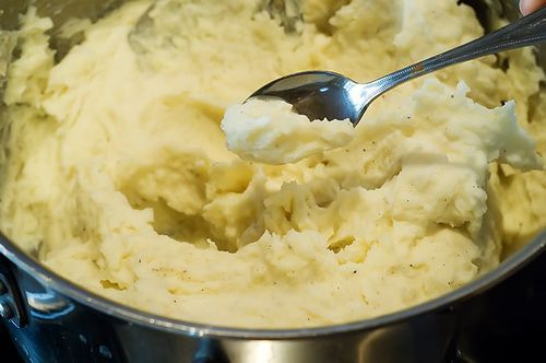 a spoon in a pot filled with mashed potatoes