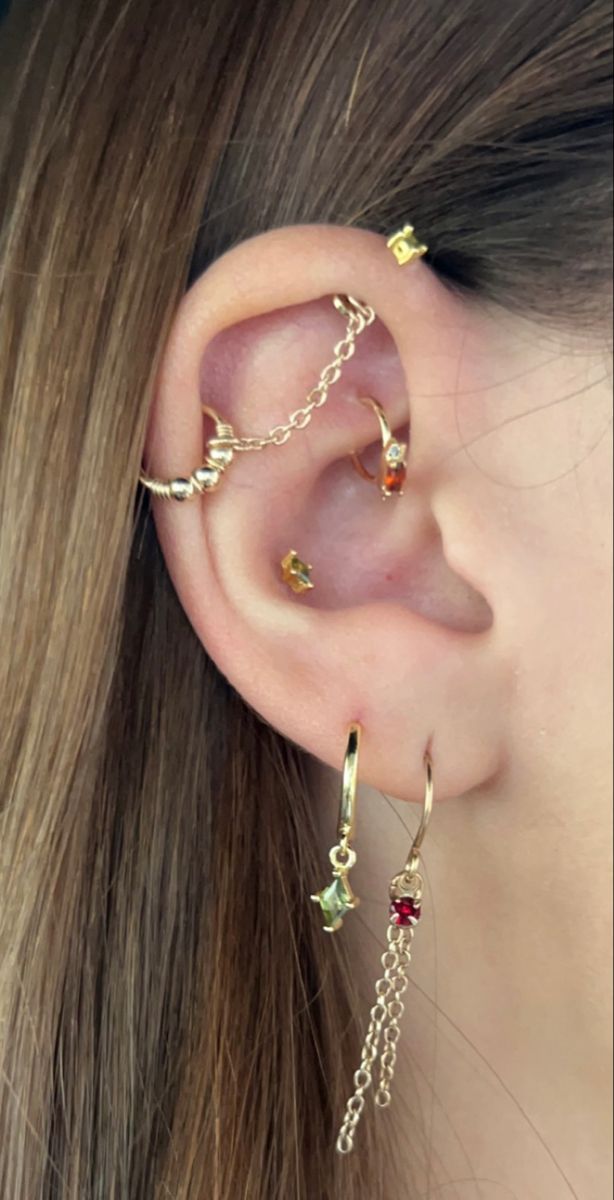 gold gem earring stack peircings gold jewlery gold gem earings, gold earings, earing inspo, peircings, earings, gold jewlery, gen earings, industrial peircing, rook peircing, chain industrial, chain earings, conch peircing Gold Chain Industrial Piercing, Conch With Chain, Conch And Industrial Piercing, Chain Ear Piercings, Gold Industrial Piercing, Chain Industrial Piercing, Piercing Stack, Chain Industrial, Earring Aesthetic