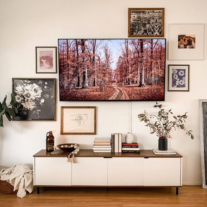 a living room filled with furniture and pictures on the wall above it's coffee table