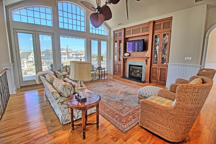 a living room with couches, chairs and a television in the middle of it