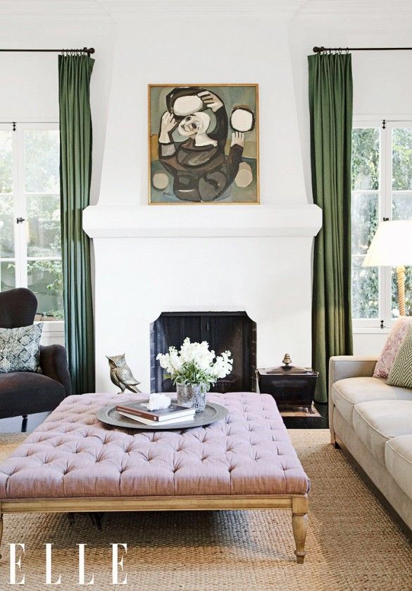 a living room filled with furniture and a painting on the wall over a fire place