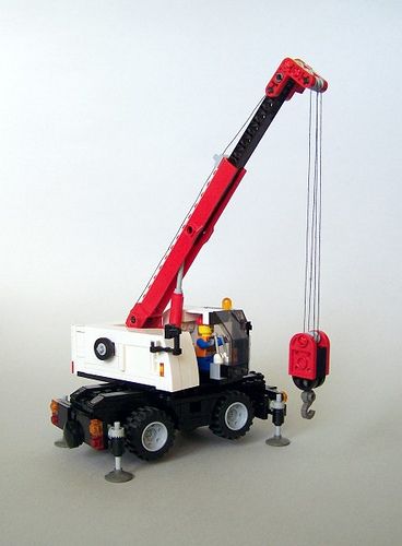 a red and white crane sitting on top of a truck