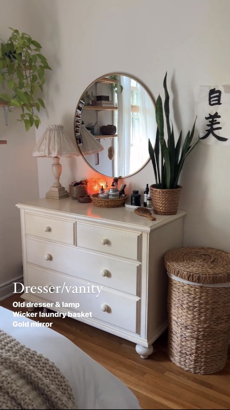 a white dresser sitting next to a mirror on top of a wooden floor