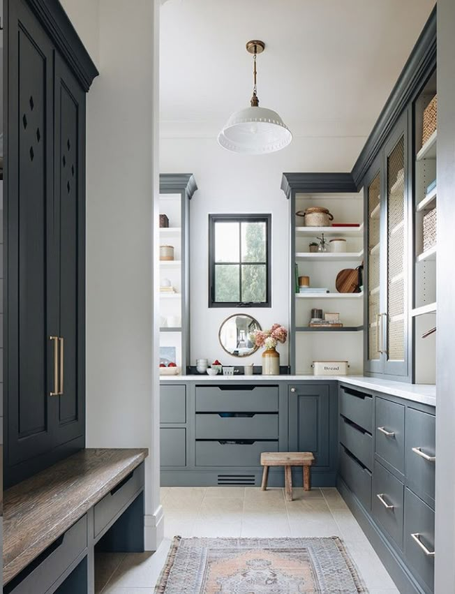 a long narrow hallway leading to a kitchen with dark wood cabinets and gray cupboards