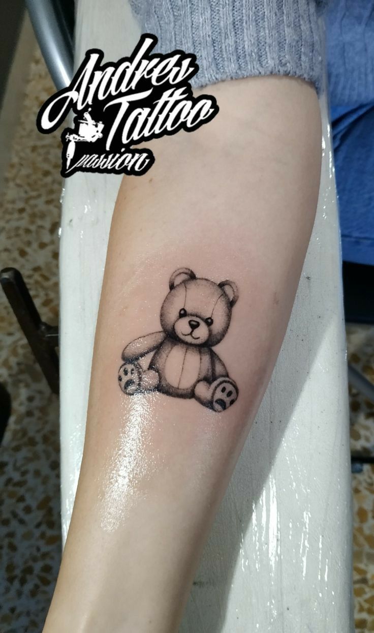 a small teddy bear tattoo on the arm