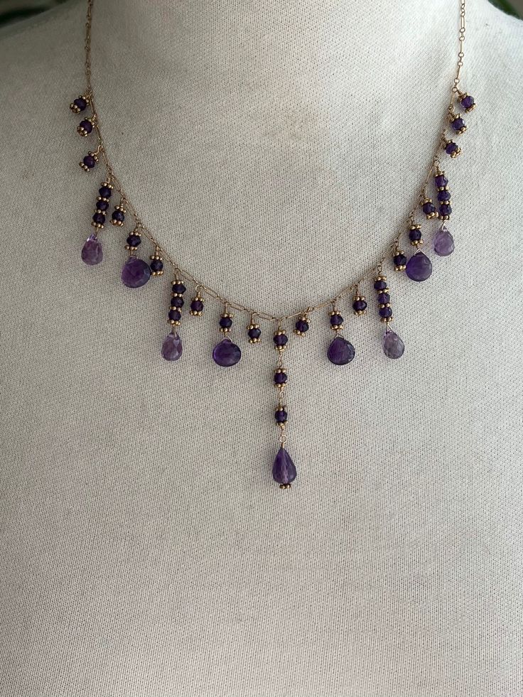 "17 1/2\" (plus 1\" extender) necklace featuring amethyst briolettes/drops, amethyst rondelles and spacer beads on chain.  I hand wire wrapped the amethyst stones with briolettes on the bottoms in various lengths onto 14k gold filled chain. Each rondelle is encased between 2 gold filled spacer beads. The longest drop length is in the center. It is 1 3/4\" long and is made up of 3.5mm amethyst rondelles with a faceted 7x11mm drop on the bottom. On each side of the center is a single amethyst rond Amethyst Beaded Necklace, Bohemian Briolette Amethyst Jewelry, Handmade Amethyst Briolette Necklace, Adjustable Purple Necklace With Dangling Beads, Adjustable Purple Necklaces With Dangling Beads, Lavender Dangling Beads For Jewelry Making, Purple Amethyst Jewelry With Dangling Beads, Purple Briolette Crystal Necklace, Purple Bohemian Briolette Jewelry