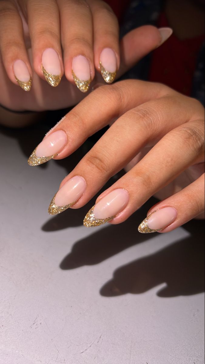 December Nails New Years, Golden Glitter French Tip Nails, Nail Ideas Gold Glitter, Gold Glitter Tip Nails French, Gold Glitter Tips Acrylic Nails, Gold Tip Nails Almond, Golden Tips Nails, Gold Sparkle French Tip Nails Almond, Neutral Nails With Gold Design