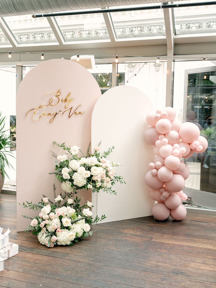 balloons and flowers are on display in front of a sign