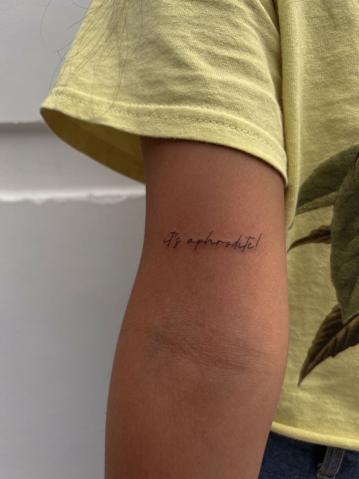 a woman with a tattoo on her arm that says it's wonderful in cursive writing