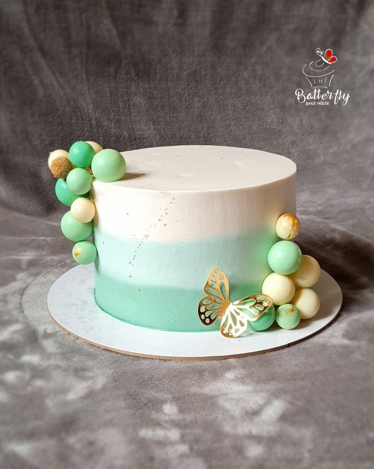 a white cake topped with green and yellow beads