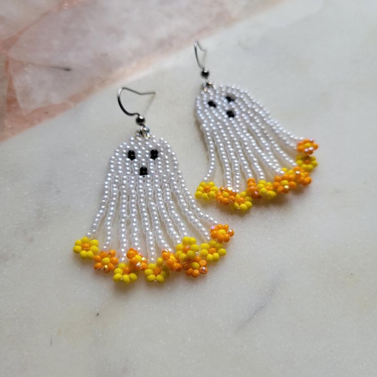 the beaded earrings are decorated with yellow and white beads