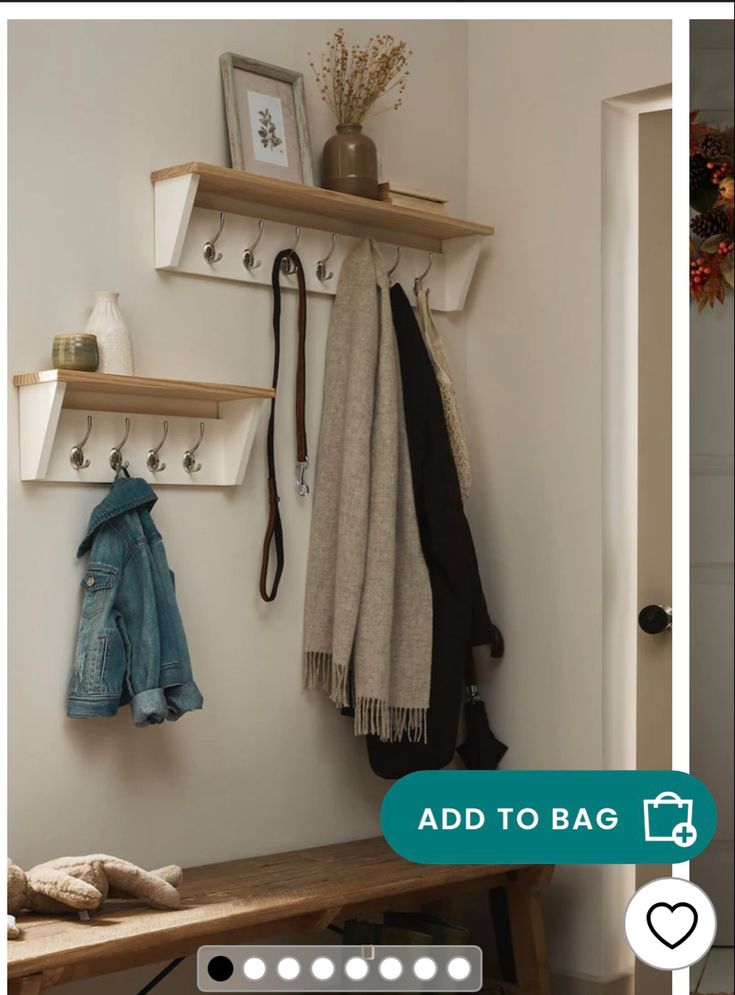 a wooden bench sitting under a coat rack next to a wall mounted shelf filled with coats