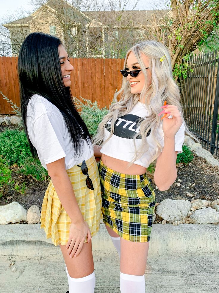 two women dressed in plaid shorts and t - shirts are standing next to each other