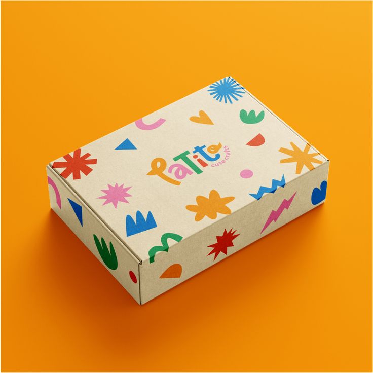 the box is decorated with colorful designs on it's sides and sits on an orange background