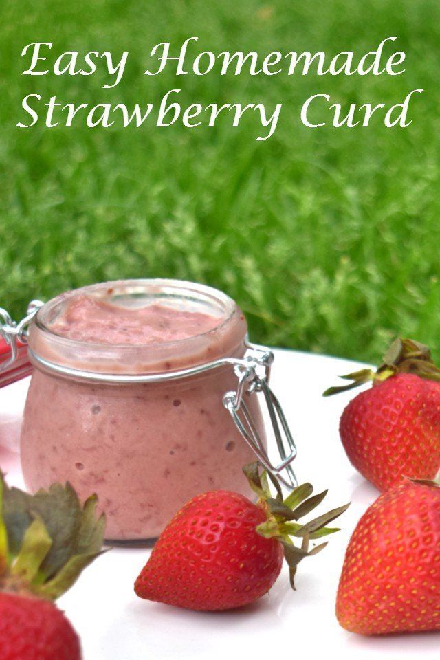 some strawberries are next to a jar of homemade strawberry curd