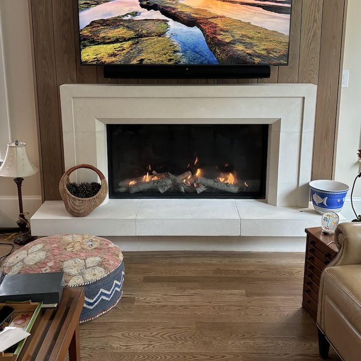 a flat screen tv mounted above a fireplace in a living room