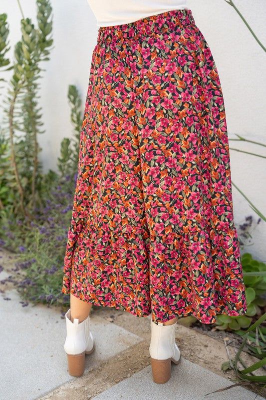 Expertly crafted and designed for comfort and style, the Floral Fantasy Midi Skirt boasts a high-waisted fit and charming floral print. The elastic waist and side pockets add convenience to this lightweight skirt. Perfect for any occasion, embrace elegance and ease with this must-have addition to your wardrobe. Model is wearing a 1X. Floral Print Tiered Skirt For Garden Party, Chic Floral Print Tiered Skirt, Tiered Skirt With Floral Print For Garden Party, Floral Print Flared Skirt Bottoms For Summer, Tiered Floral Print Skirt For Garden Party, Chic Skirted Bottoms With Floral Print, Floral Print Flowy Skirt, Summer Floral Print Voluminous Maxi Skirt, Flowy Tiered Skirt With Floral Print