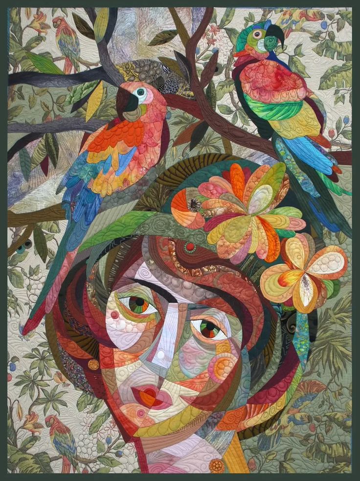 a woman's face is surrounded by birds on a quilted wall hanging in front of a blue wall