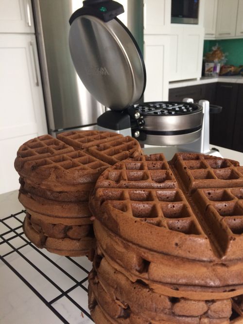 two waffles stacked on top of each other with a coffee maker in the background